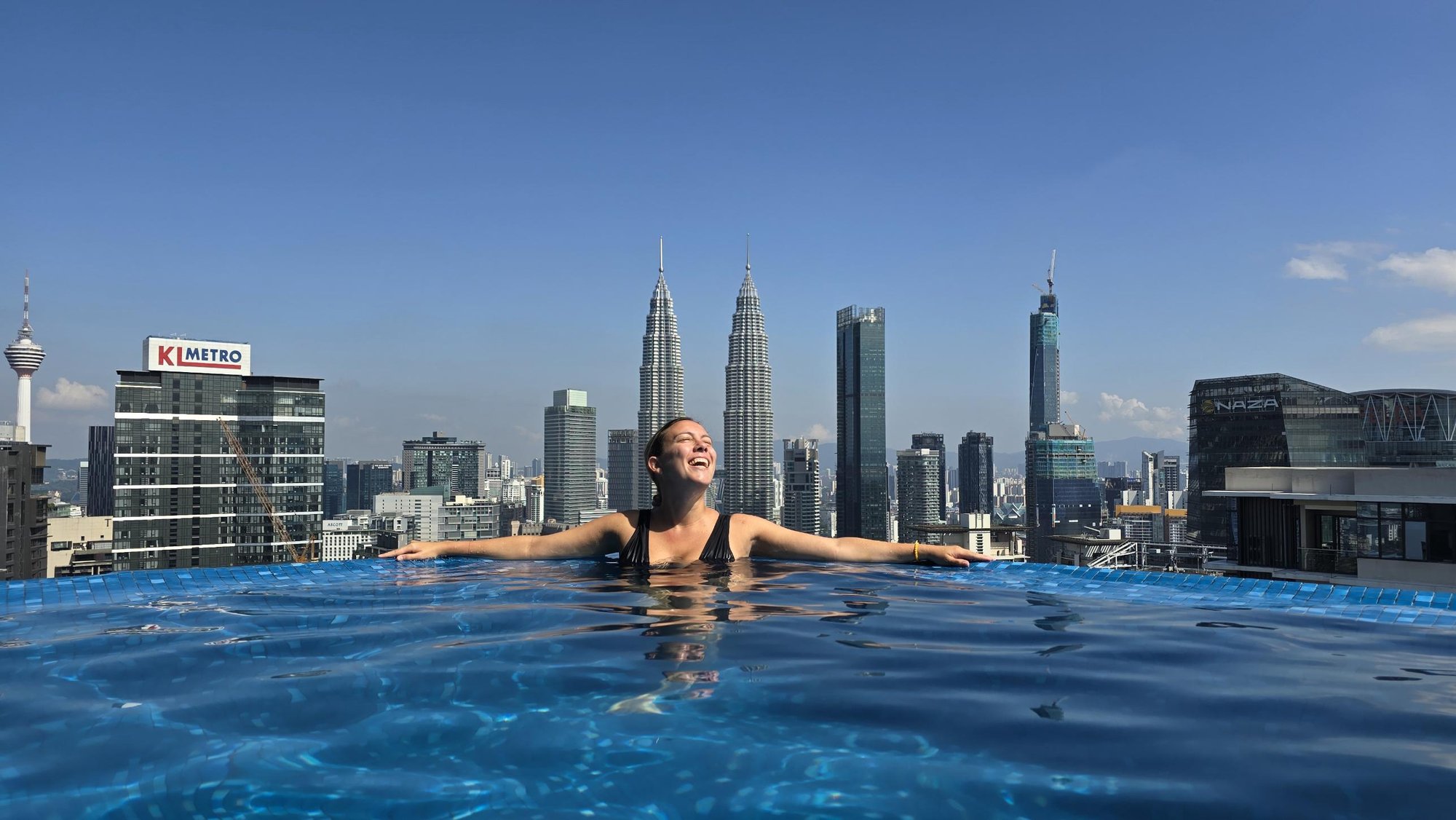 Sandra en una piscina en las alturas de Kuala Lumpur, con las Torres Petronas al fondo